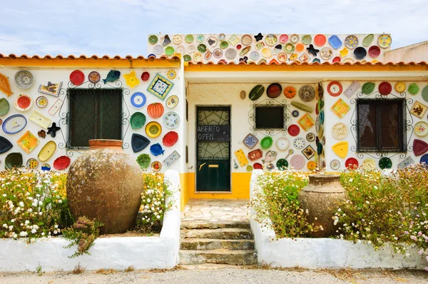 ALGARVE, PORTUGAL - MAY 3, 2015: Traditional colorful ceramic plates on the wall of the local pottery shop.  Algarve is famous for its hand-painted pottery and ceramics.