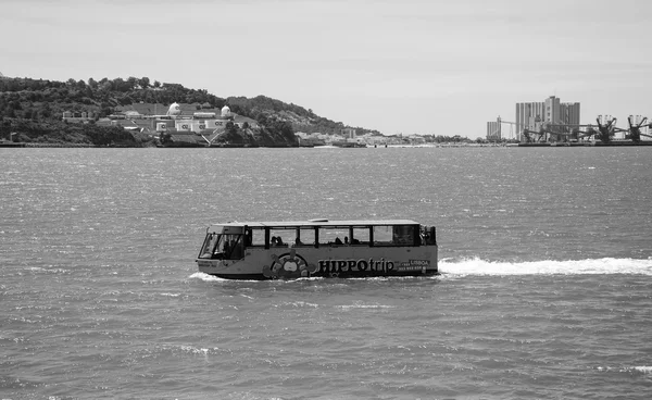 LISBON, PORTUGAL - APRIL 22, 2015: Sightseeing amphibian bus HIPPOtrip is crossing river Tagus with the tourists.