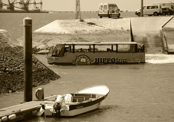 LISBON, PORTUGAL - APRIL 22, 2015: Sightseeing amphibian bus HIPPOtrip is entering into the river Tagus with the tourists.