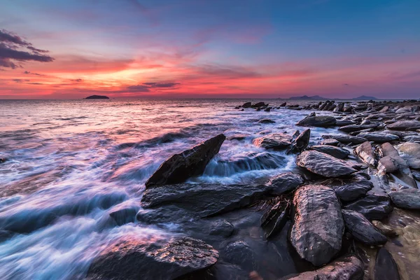 The rocks at the beach during sunset. Motion blur, soft focus