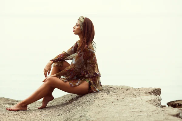 Gorgeous bikini woman sitting on beach with nice figure