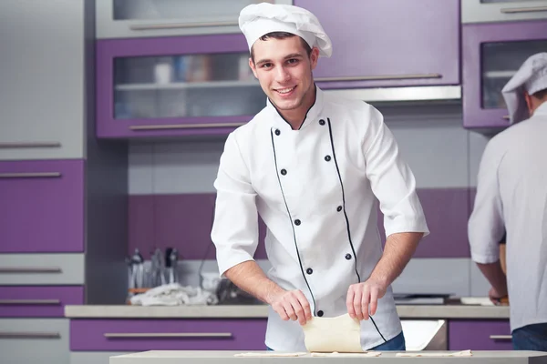 Vegetarian bakery concept. Smiling chef cook in uniform making dessert