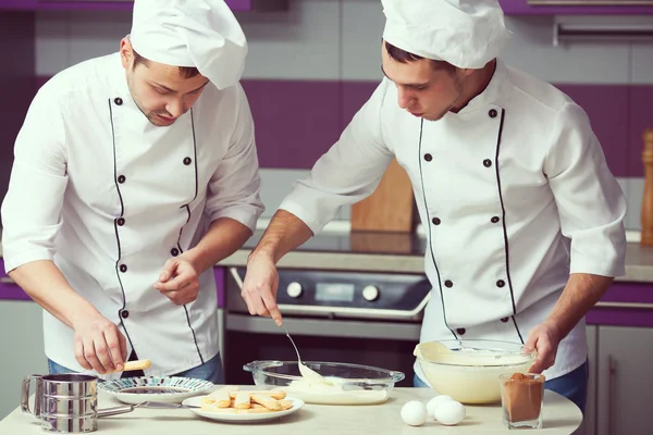 Tiramisu cooking concept. Portrait of two working men in cook un
