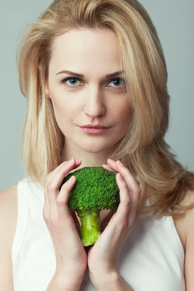 Raw, living food, veggie concept. Portrait of young woman with broccoli