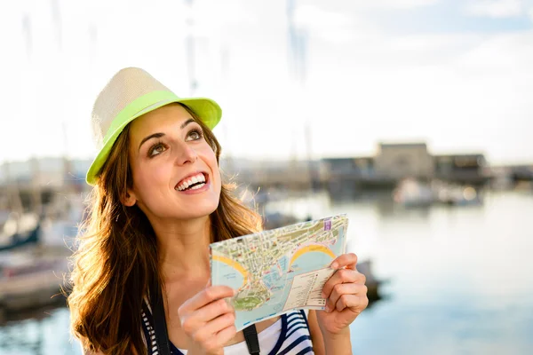 Tourist with map on summer travel by the harbor