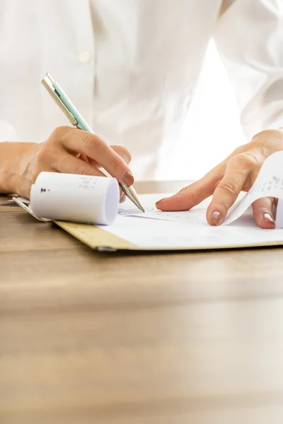 Closeup of female hands making calculations or annual report