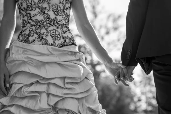 Close up on bride and groom holding hands