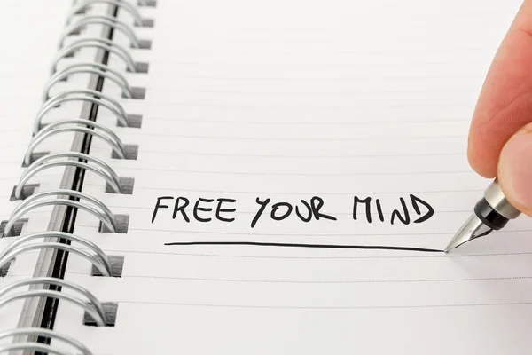 Hand with Pen Writing Free Your Mind in Notebook