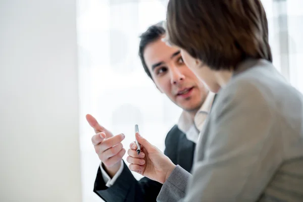 Businesswoman offering a pen to her business partner