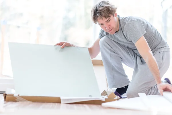 Man unpacking flat pack components