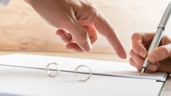 Male hand pointing to a divorce paper