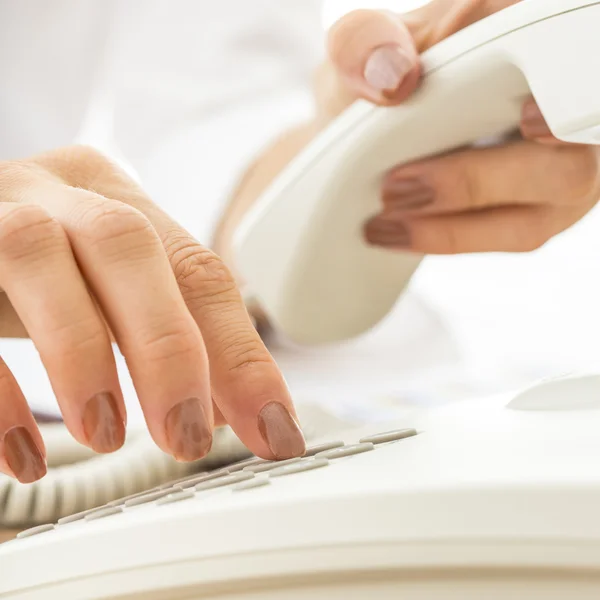 Closeup of female telephone operator dialing a phone number