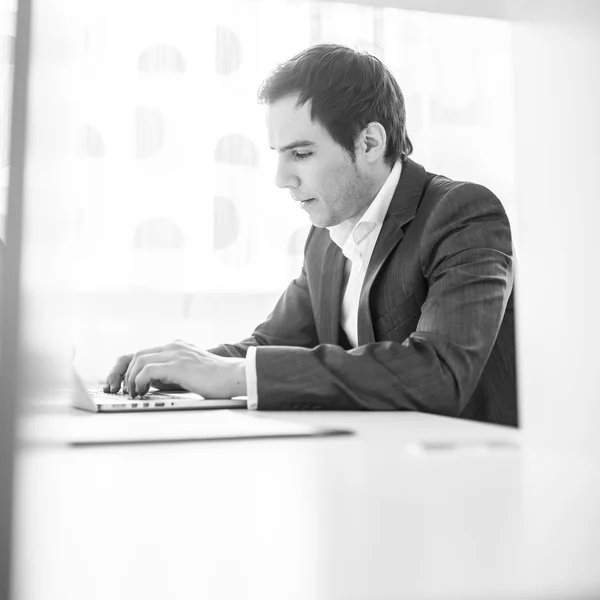 Young businessman, programmer or student sitting at his desk wor