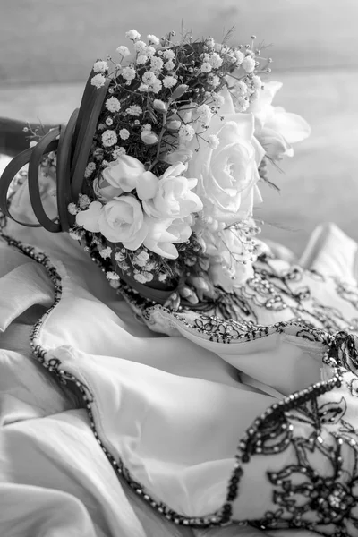 Beautiful wedding bouquet lying on a wedding gown