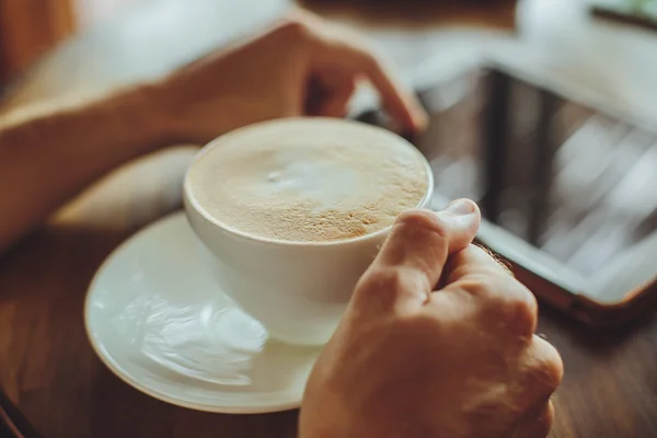 Male hand, coffee and book on the table