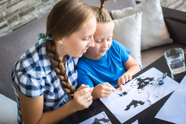 Mom with son draw a flying mouse