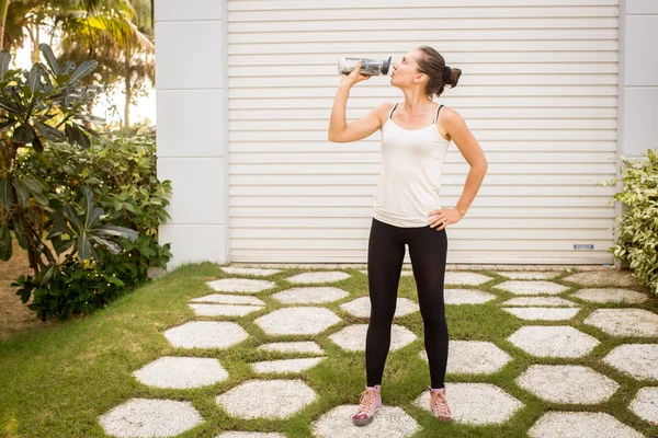 Woman drinks water after sport