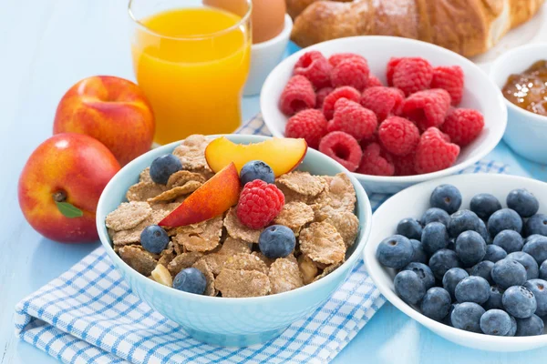 Healthy breakfast with flakes, fresh fruit and berries on table