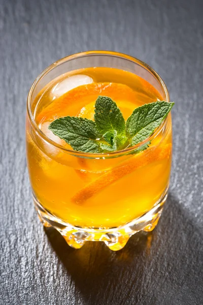 Orange lemonade with ice in a glass, top view