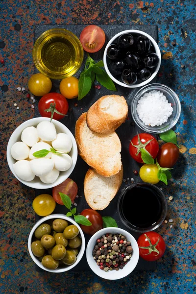 Mozzarella, ingredients for the salad and bread, vertical