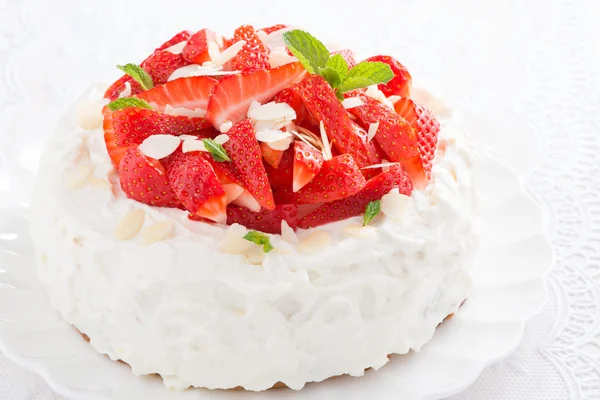 Cake with whipped cream and strawberries, close-up