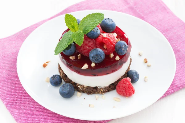 Delicious cake with fruit jelly and fresh berries on a plate