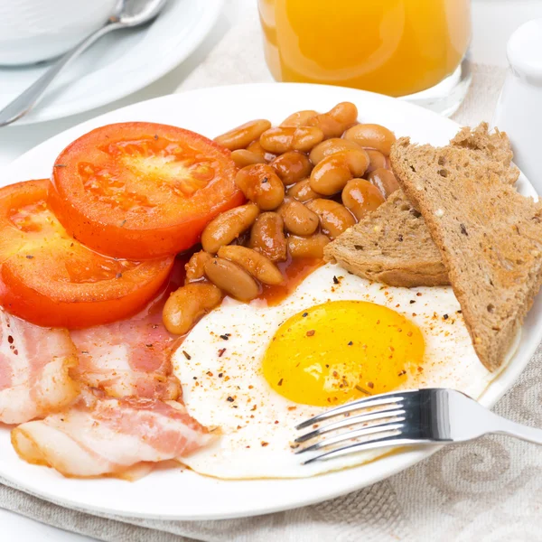 Traditional English breakfast with fried eggs, bacon, beans