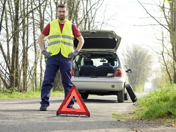 Man fixing a car problem after vehicle breakdown on the road