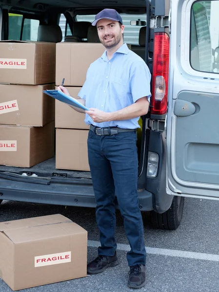 Portrait of confidence express courier next to his delivery van