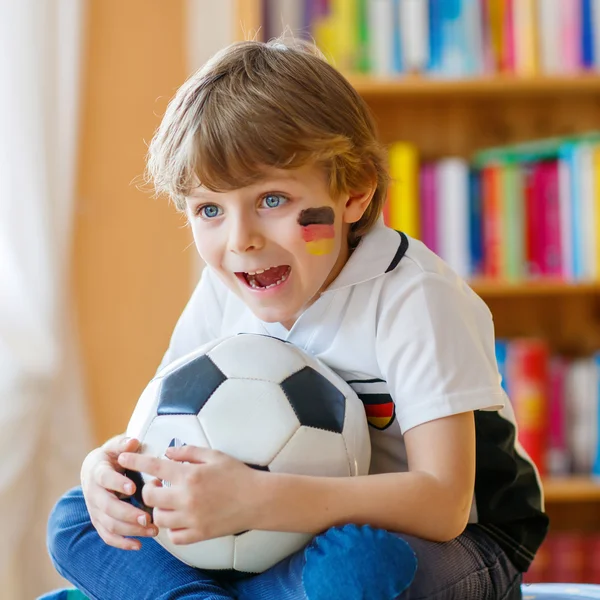 Kid boy watching soccer or football game on tv