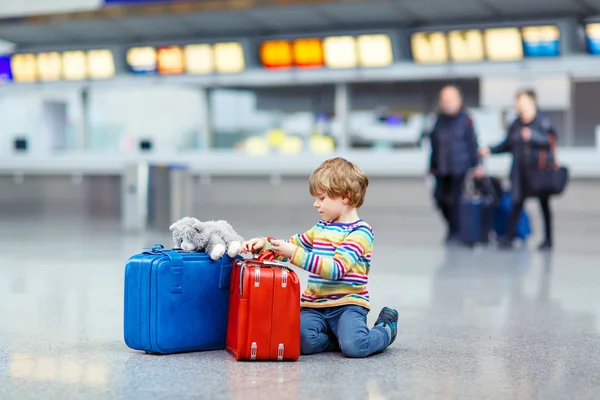 Little kid boy with suitcases on international airport