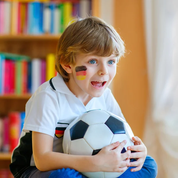 Kid boy watching soccer or football game on tv