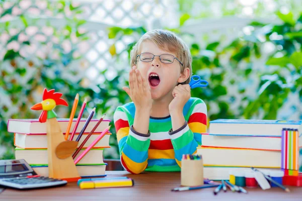 Sad school kid boy with glasses and student stuff