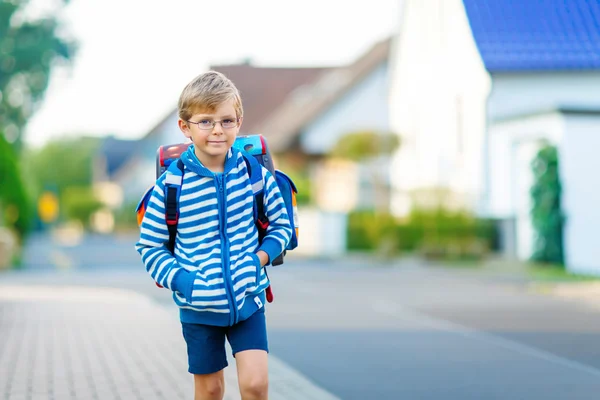 Little kid boy with school satchel on way to school