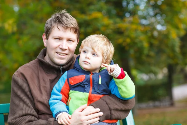 Young dad and his little toddler child in colorful clothes sitti