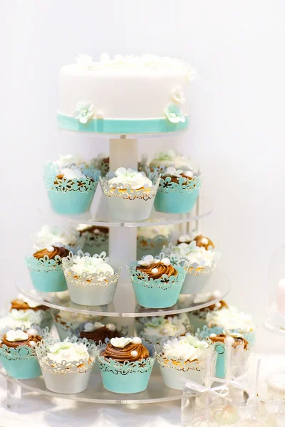 Wedding cake and cupcakes in brown and cream in blue, white and