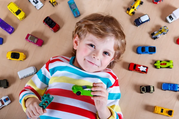 Adorable cute child with lot of different colorful toy cars