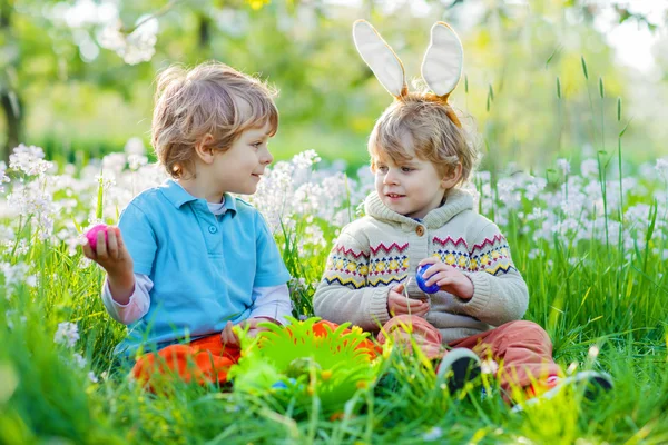Two little kid boys on Easter during egg hunt