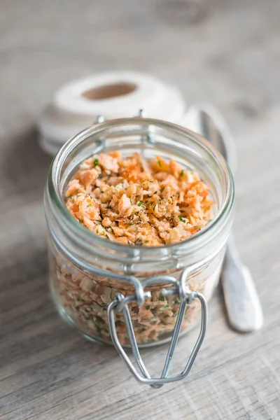 Roasted and smoked salmon fish, soft cheese and egg pate in glass jar, selective focus