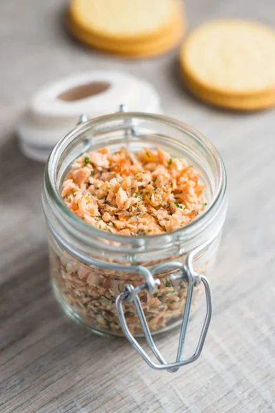 Roasted and smoked salmon fish, soft cheese and egg pate in glass jar, selective focus
