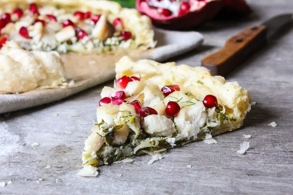 Puff pastry pie with fish cod fillet, spinach, dill, pomegranate seeds and cream cheese, selective focus