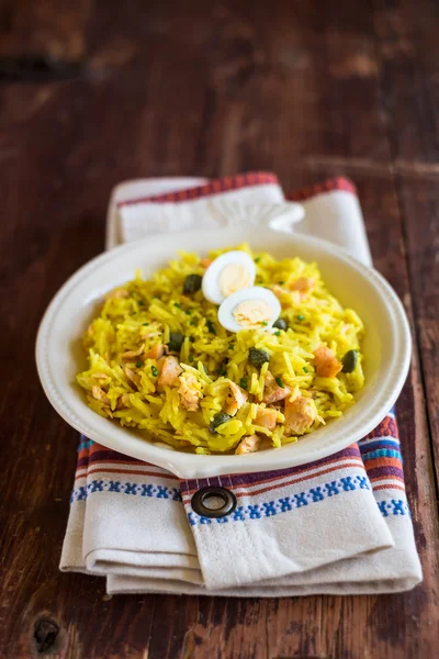 National scottish dish kedgeree with roasted basmati rice, curry powder and fish in a plate, selective focus