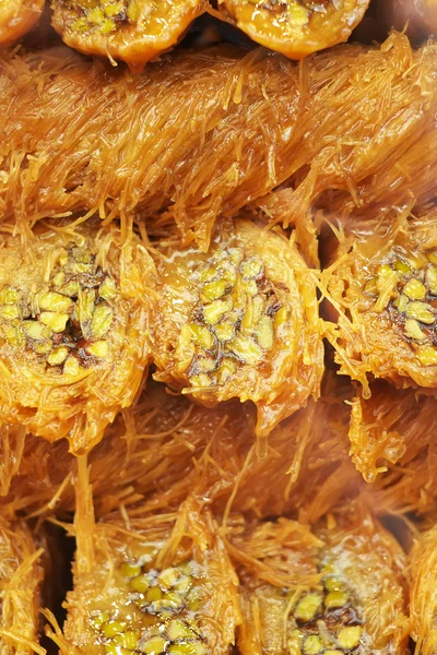 Turkish sweet baklava with honey and pistachios, selective focus