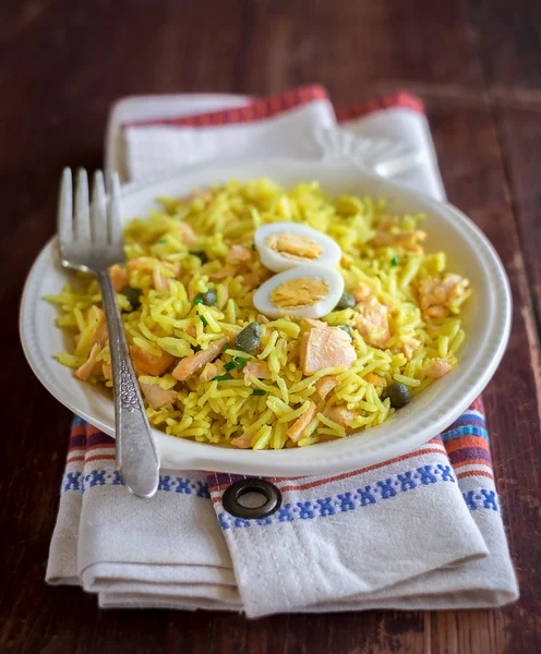Traditional scottish dish Kedgeree consisting of cooked, flaked fish, boiled rice, parsley, hard-boiled eggs, curry powder, butter