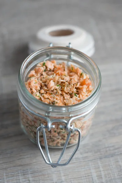 Roasted and smoked salmon and soft cheese spread with dill and butter served with cheese crackers, selective focus