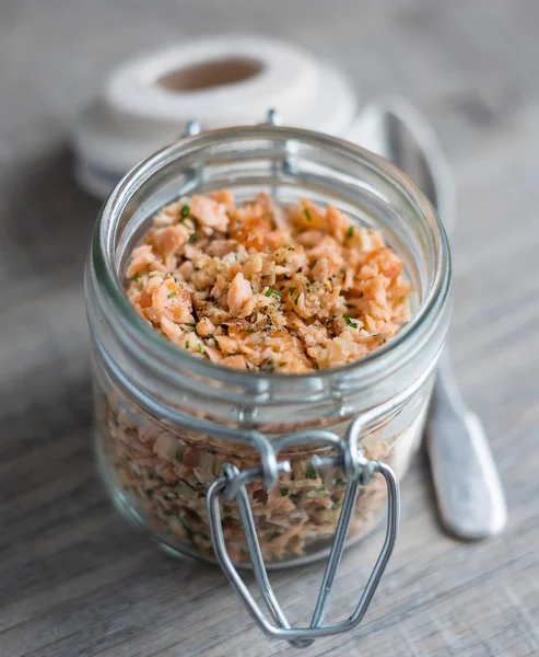 Roasted and smoked salmon fish, soft cheese and egg pate in glass jar, selective focus