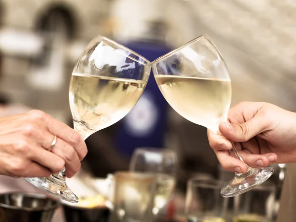 Two People Touching Glasses of White Wine Celebrating an Event o