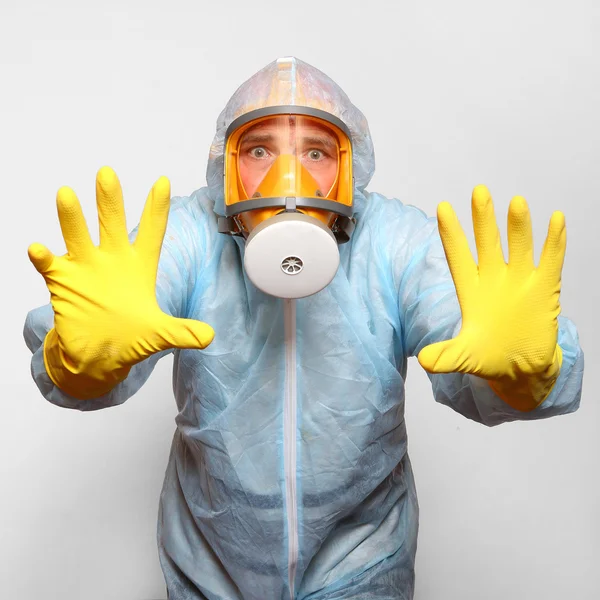 Man in protective clothing with respirator.