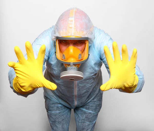 Man in protective clothing with respirator.