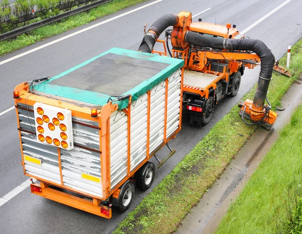 Maintenance on the highway mowing the lawn.